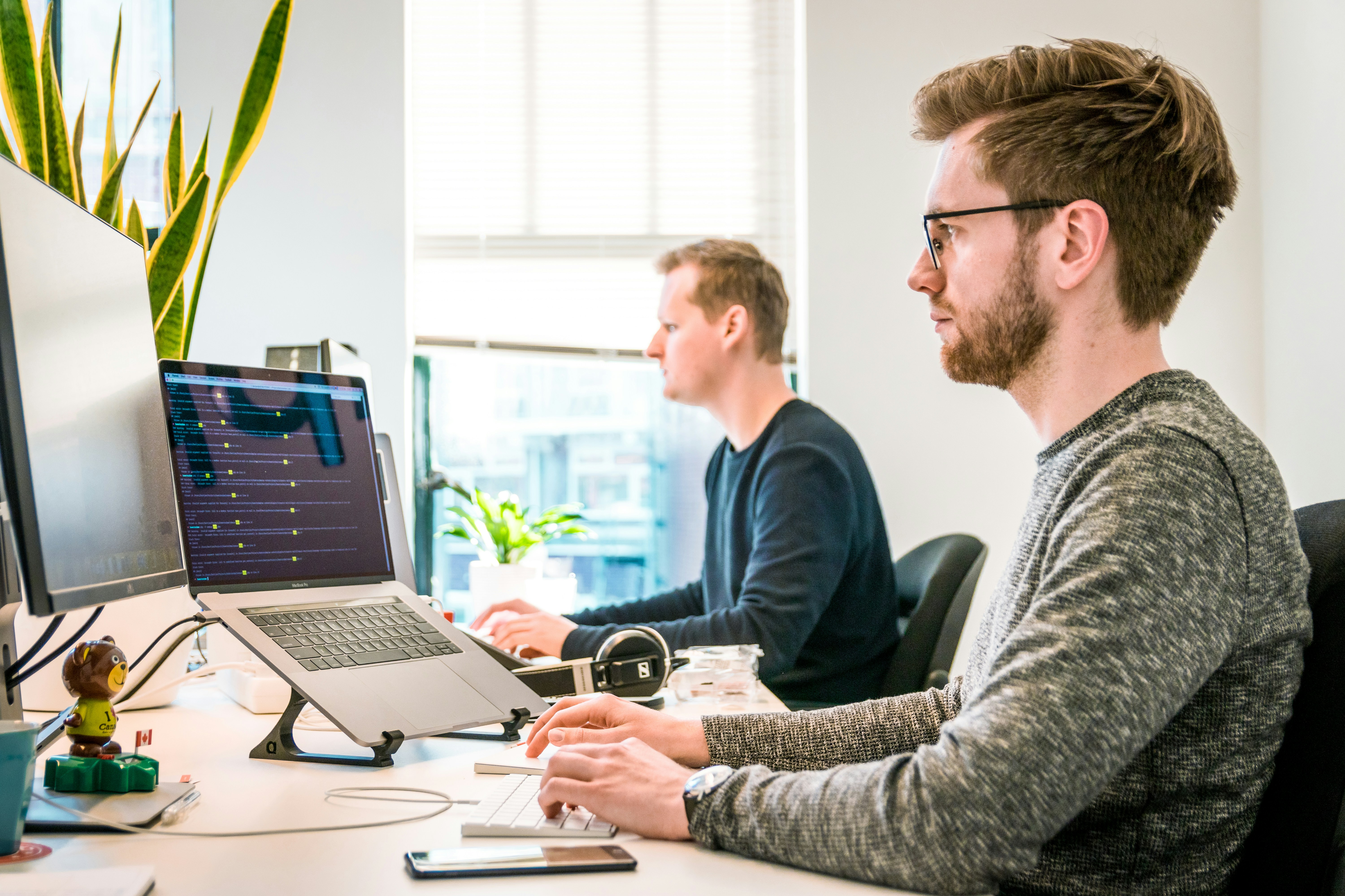 Focused software engineer working on a laptop in a bright space